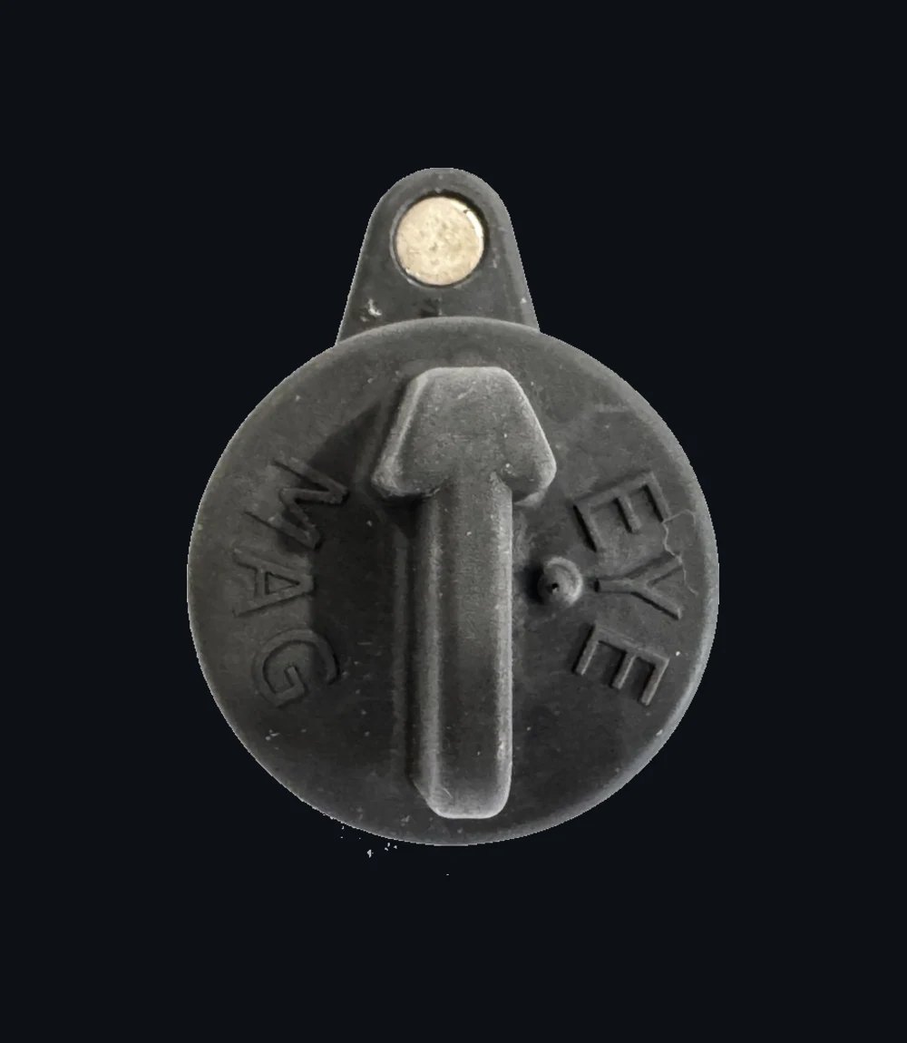 Magnetic Hub Plug face, embossed arrow flanked by MAG and EYE, with the silver magnet seated in the tab